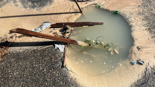 На улице Зарубина из-под асфальта неделю течет вода
